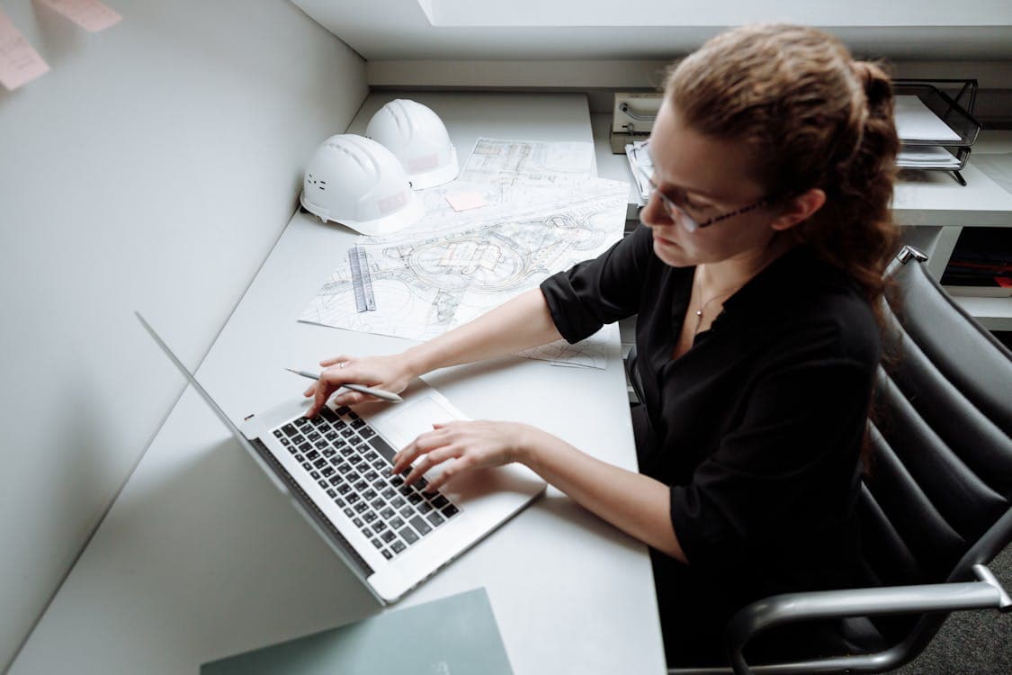 Architetto al laptop con documenti di progetto