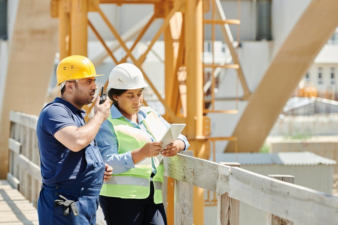 Due tecnici in cantiere consultano un tablet durante i lavori